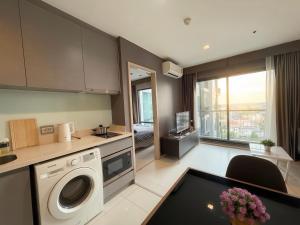 a kitchen with a washing machine and a living room at BTS Thong Lor Central High -rise Condo in Bangkok