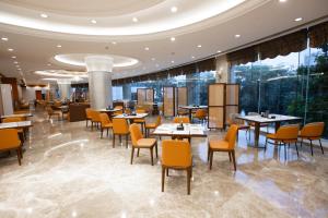 a restaurant with tables and chairs and windows at Empark Grand Hotel Fuzhou in Fuzhou