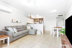 a living room with a couch and a kitchen at Sea Air 6 in Yeppoon