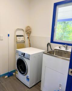 a laundry room with a washing machine and a sink at Kuki Kainga in Matavera