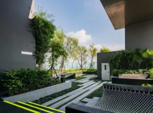 a courtyard of a building with benches and plants at BTS Thong Lor Central High -rise Condo in Bangkok