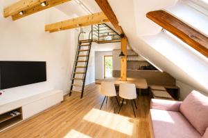 a loft conversion with a living room and a ladder at Dovce Apartments in Rakek