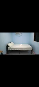 a bed in a room with a blue wall at Hatch Guesthouse in Ocoy