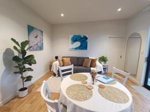 ein Wohnzimmer mit einem Tisch und einem Sofa in der Unterkunft The Tiny Abode in Snells Beach