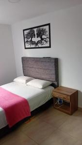 a bedroom with a bed and a wooden table at Bello apto en armenia 1306 in Armenia +18 photos