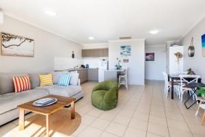 a living room with a couch and a table at Sea Air 24 in Yeppoon +7 photos