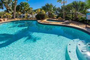 a swimming pool with blue water in a resort at Sea Air 24 in Yeppoon