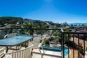a balcony with a table and chairs and a pool at Sea Air 24 in Yeppoon