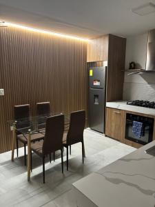 a kitchen with a table and chairs and a refrigerator at DEPARTAMENTO DUPLEX 3 Habitaciones EN CUENCA ECUADOR in Cuenca +8 photos