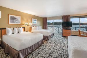 a hotel room with two beds and a balcony at Glen Lyon Inn in Port Hardy