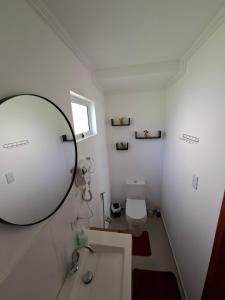 ein Badezimmer mit Spiegel und Waschbecken in der Unterkunft Chalé Cabana Ruby in Gonçalves + 15 Fotos