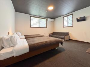a bedroom with a large bed and a chair at Pension Kobekko in Otari +65 photos