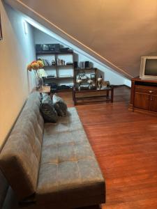 a living room with a couch and a television at DEPARTAMENTO DUPLEX 3 Habitaciones EN CUENCA ECUADOR in Cuenca