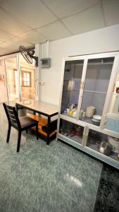 a kitchen with a table and a counter with a dining room at Traditional Thai House Chaloklum in Chaloklum
