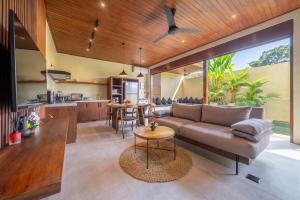 an open kitchen and living room with a couch and a table at Nala Villa - Peaceful Hideaway with Pool & Yoga Space in Canggu