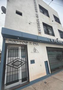 a building with barred windows and a sign on it at Acordes de Gaitas - Departamento 1 in Malargüe