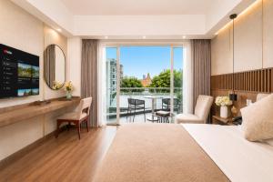 a hotel room with a bed and a view of a balcony at Harmony Phnom Penh Hotel in Phnom Penh