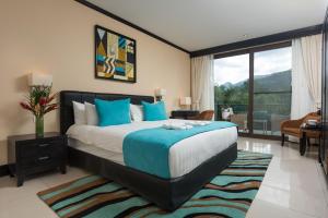 a bedroom with a large bed and a balcony at The Royal Corin Thermal Water Spa & Resort - Adults Only in Fortuna