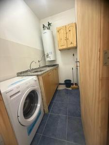 a laundry room with a washing machine and a sink at Acordes de Gaitas - Departamento 1 in Malargüe