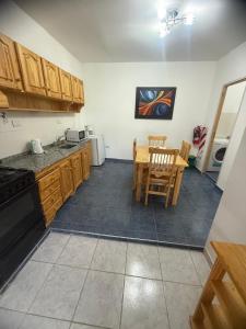 a kitchen with wooden cabinets and a table and chairs at Acordes de Gaitas - Departamento 1 in Malargüe