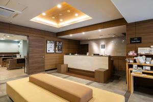 a lobby of a store with a bench and a counter at KOKO HOTEL Takamatsu in Takamatsu