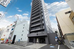 a tall building on the corner of a street at KOKO HOTEL Takamatsu in Takamatsu