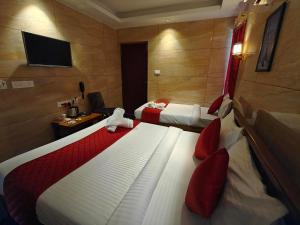 a hotel room with two beds and a television at PV Tower - Auro Beach in Kuilapayam