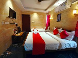a hotel room with a large bed with red and white pillows at PV Tower - Auro Beach in Kuilapayam +94 photos