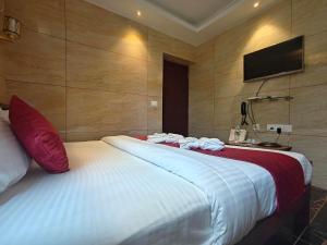 a bedroom with two beds and a flat screen tv at PV Tower - Auro Beach in Kuilapayam