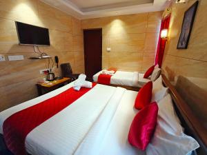 a hotel room with two beds and a television at PV Tower - Auro Beach in Kuilapayam