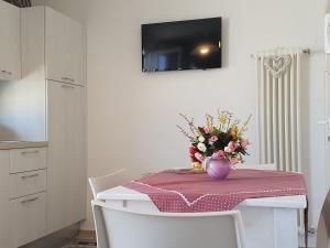 een eettafel met een vaas met bloemen erop bij Pietra di Luna relaxing private terrace in Polignano a Mare