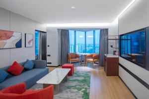 a living room with a blue couch and red chairs at Wyndham Garden Haikou Meilan in Haikou