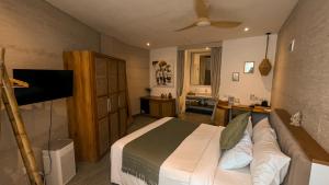 a bedroom with a bed and a television in it at Mantra Wellness Center in Uluwatu