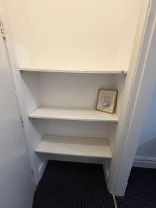 a closet with white shelves and a picture in it at The Navigation Inn Hotel in Derby