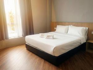 a large white bed in a room with a window at Roxy Hotel Selangau in Rumah Kudan +6 photos