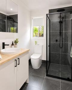 a bathroom with a shower and a toilet and a sink at William's on William - Stylish 2 Bedroom Haven in Ormiston +2 photos