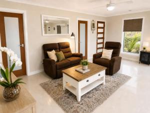 a living room with a couch and a coffee table at William's on William - Stylish 2 Bedroom Haven in Ormiston
