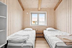 two beds in a small room with a window at FY173-Asperup-Elmevaenget-8 in Asperup