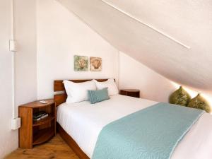 a bedroom with a white bed with a blue blanket at Beachfront condo with loft and sea views in Puerto Aventuras +25 photos