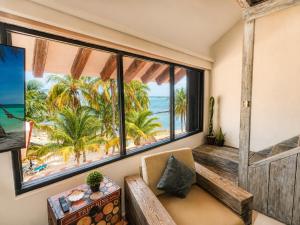 a room with a bench and a view of the ocean at Beachfront condo with loft and sea views in Puerto Aventuras