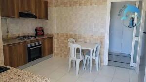 a kitchen with a white table and white chairs at Résidence Marina in Sousse