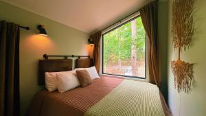 a bedroom with a bed with a large window at Bison Farm - Cabin "Cielo" in Culpeper