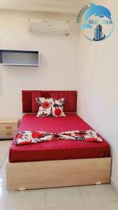 a bedroom with a bed with a red bedspread at Résidence Marina in Sousse