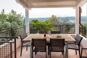 eine Terrasse mit einem Holztisch und Stühlen auf dem Balkon in der Unterkunft Villa Marchetti in Cupra Marittima