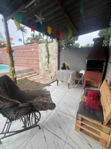 an outdoor patio with a table and a fireplace at Casa com piscina in Belfort Roxo