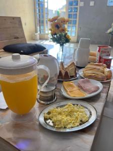 a table with plates of food and a cup of beer at Casa com piscina in Belfort Roxo