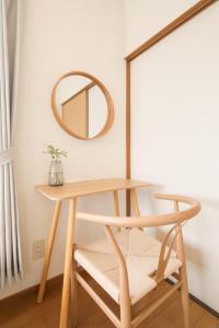a dressing table with a mirror and a chair at Matsumoto BASE in Matsumoto