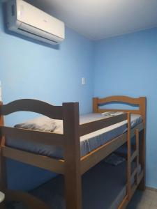 a bunk bed in a room with a blue wall at Pousada Hostel Beach Pajuçara in Maceió