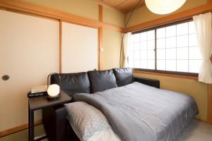 a bedroom with a bed with a table and a window at Matsumoto BASE in Matsumoto