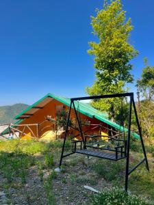 a swing in the grass in front of a building at Orchard Valley Resort in Mai Jūbar